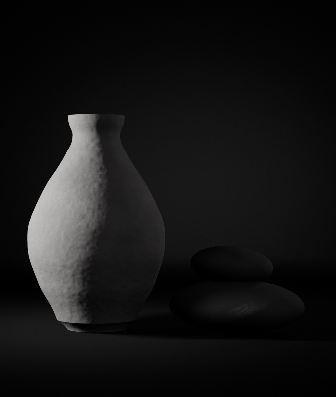 Matte hand-thrown vase and two balanced stones in raking light